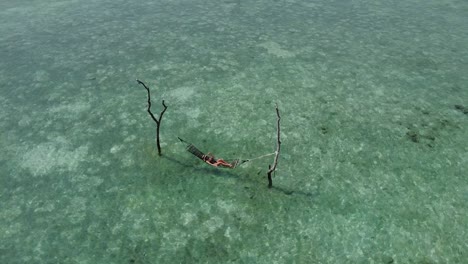 Drone-shoot-of-a-girl-in-hammock,-a-beautiful-Maldivian-island