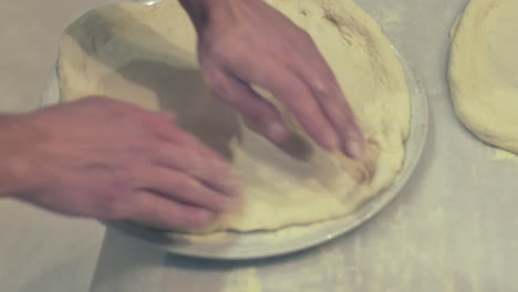 Italian-Chef-showing-how-to-place-the-pizza-dough-on-a-place-before-the-Pizza-dressing