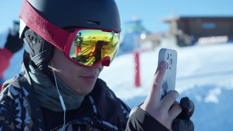 Close-up-of-a-young-person-filming-with-a-cell-phone-on-a-ski-slope-on-a-sunny-day