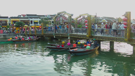 Filmischer-Blick-Auf-Die-Fußgängerbrücke-über-Den-Fluss-Mit-Auf-Dem-Fluss-Schwimmenden-Booten-Bei-Sonnenuntergang-In-Der-Altstadt-Von-Hoi-An,-Vietnam