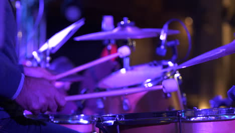 Drummer-playing-at-concert-wearing-suit,-close-up-hands-view