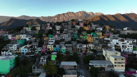 Aerial-view-over-a-poor-area,-revealing-a-wealhy-district,-sunset-in-Monterrey,-Mexico