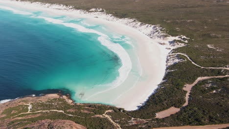 Waves-from-the-turquoise-see-rolling-onto-an-empty-white-beach