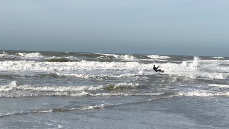 Kite-Surfer-starting-from-shoreline-with-board-into-ocean-waves-and-jumping-into-sky---real-time