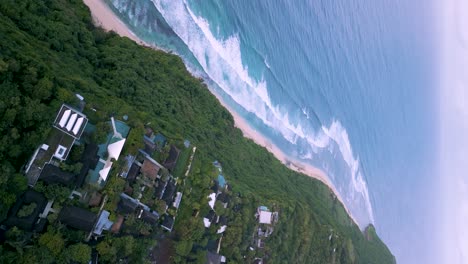 High-angle-drone-panning-shot-of-holiday-cabins-next-to-the-sea