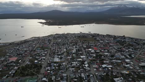 Puerto-Natales-Cityscape,-Chilean-Patagonian-City,-Aerial-Drone-Above-Town,-Gulf-Montt-Water-and-Dreamy-Peaceful-Landscape