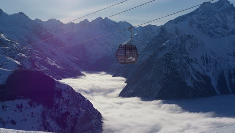 Static-video-of-a-cable-car-going-up-on-the-snowy-high-mountains-in-sunny-day