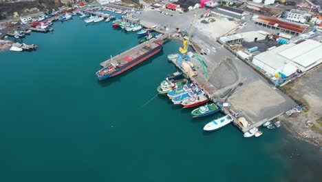 Port-of-Shengjin-in-Albania,-piers-where-fishing-and-commercial-ships-are-anchored-with-unloading-cranes