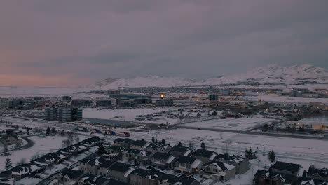 Frontrunner-commuter-train-pulls-into-the-Lehi,-Utah-station-after-a-snowstorm---aerial