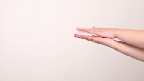 A-pair-of-hands-clapping-sideways-on-the-right-side-in-front-of-a-white-background