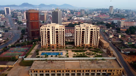 Aerial-view-away-from-modern-condominium,-in-sunny-Yaounde,-Cameroon---pull-back,-drone-shot