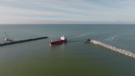 Luftaufnahme:-Ein-Rotes-Frachtschiff-Fährt-Durch-Die-Hafentore-Der-Stadt-Klaipeda