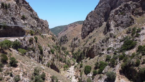 Cars-driving-on-scenic-mountain-pass-on-edge-of-Topoliana-Gorge,-Crete