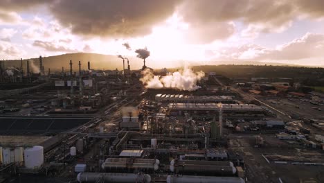 Aerial-shot-of-refinery-at-golden-hour-on-a-gloomy,-cloudy-day