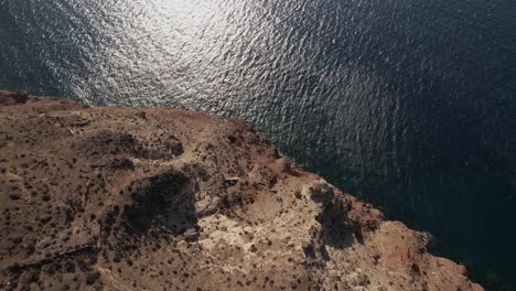 Santorini-Island,-Greece,-Flying-Above-Scenic-Coastline-and-Volcanic-Cliffs,-Drone-Shot