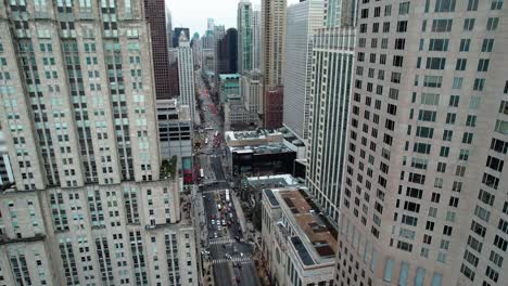 Entre-Rascacielos-En-Chicago,-Pequeña-Inclinación-Hacia-Abajo-Y-Vuelo-Hacia-Atrás-Antena-Illinois-Usa-4k