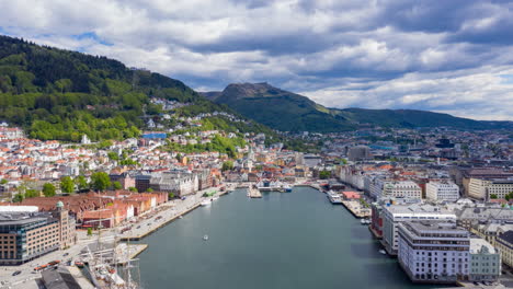 Drone-hyperlapse-showing-the-famous-landmark-Bryggen-in-Bergen-with-boats,-traffic-and-moving-clouds