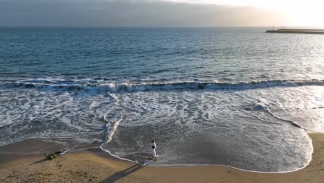 Drone-shot-Couple-walking-along-the-beach