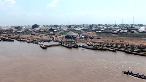 Long-wooden-rafts-used-to-ferry-people-and-vehicles-across-the-Benue-River-near-Ibi-Town,-Nigeria