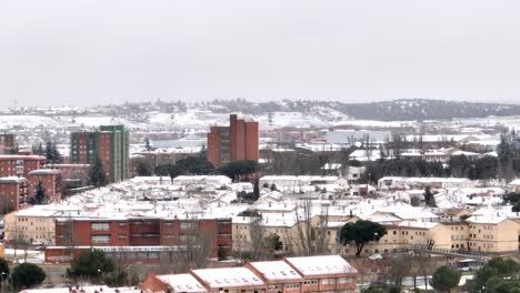 Downtown-of-the-city-of-Salamanca-covered-in-snow-after-a-snow-storm,-aerial-view