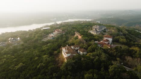 Upscale-Suburban-Homes-in-Westlake,-Austin-Texas-overlooking-Lake-Austin-Aerial-pan-right-orbit-at-sunrise-in-4k