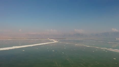 4K-Aerial-drone-dolly-in-of-salty-sea-over-the-Dead-sea-hotel-zone
