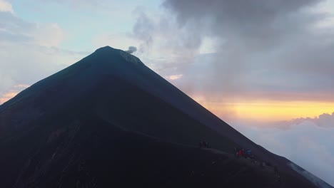 A-lot-of-smoke-coming-out-from-a-volcano-with-people-watching-it-on-a-ridge-close-by