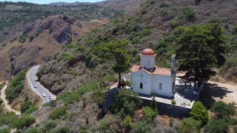 Church-of-Agios-Panton-in-Topolia-village,-Crete,-overlooking-Greek-mountain-valley,-Aerial-view