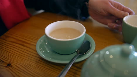 A-woman-pouring-milk-into-tea-cup