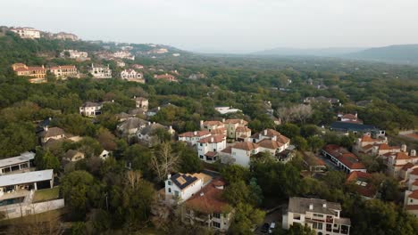 Upscale-Neighborhood-Homes-and-Condos-in-Westlake,-Austin-Texas-overlooking-Lake-Austin-Aerial-pan-left-at-sunrise-in-4k