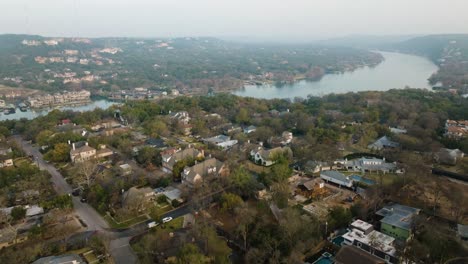 Lake-Austin-and-Suburban-Neighborhood-Homes-in-Tarrytown,-Austin-Texas-Aerial-tilt-up-at-sunrise-in-4k