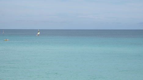 Hermoso-Mar-Azul-Con-Gente-Haciendo-Windsurf-Y-Kayak