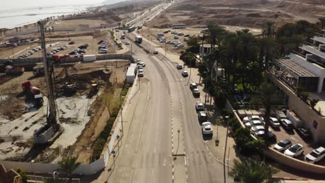 4K-Aerial-drone-pan-up-over-desert-road-dead-sea-hotel-zone