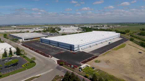 High-orbiting-drone-shot-of-a-new-warehouse-in-an-industrial-area