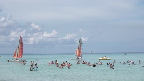 Gente-Disfrutando-De-La-Playa,-Bañándose,-Navegando-O-Haciendo-Kayak