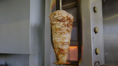 Chicken-Shawarma-Skewer-Hanged-On-Grill-Turning-Around-On-Fire