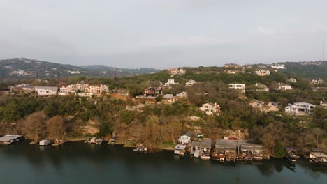 Suburban-Neighborhood-Homes-in-Westlake,-Austin-Texas-overlooking-Lake-Austin-Aerial-pan-left-at-sunrise-in-4k