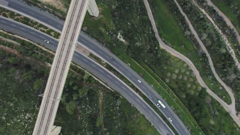 Top-down-view-of-a-main-road-and-a-railway-bridge-in-a-green-area