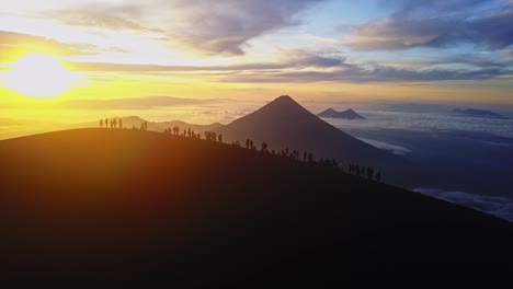 Gruppe-Von-Menschen,-Die-Im-Sonnenaufgang-Auf-Einem-Vulkan-Stehen