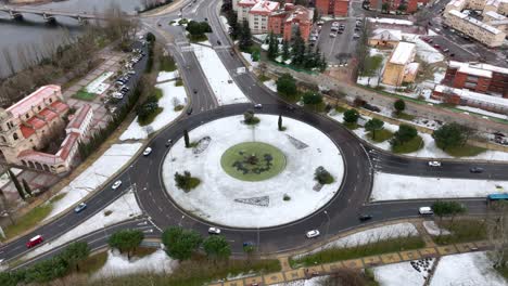 Aerial-view-over-a-roundabout-covered-in-snow-in-Salamanca,-Spain