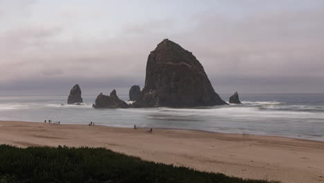 Wide-shot-of-Cannon-Beach-and-the-famous-Haystack-Rock-with-people-on-the-beach