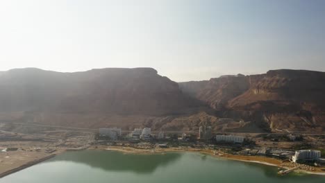 4K-Aerial-drone-pan-up-of-rocky-mountains-near-the-dead-sea-hotel-zone