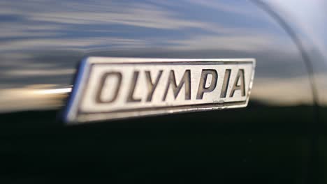 Opel-Olympia-Oldtimer-Logo-Emblem-Makroaufnahme-Auf-Einem-Schieberegler,-50-Fps-Zeitlupe