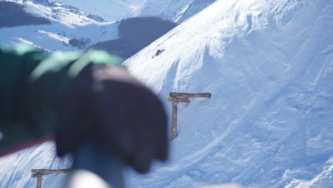 Nahaufnahme-Mit-Unterschiedlichem-Fokus-Zwischen-Den-Handschuhen-Eines-Skifahrers-Auf-Einem-Sessellift-Und-Der-Verschneiten-Skipiste