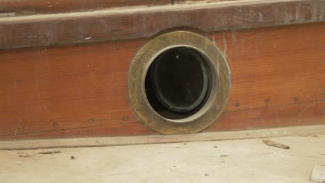 Brass-porthole-window-in-traditional-wooden-sailboat