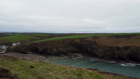 Panning-Aerial-Over-Nolton-Haven-Towards-Beach-and-Sea-with-Dramatic-Pembrokeshire-Coastline-and-Cloudy-Sky-UK-4K