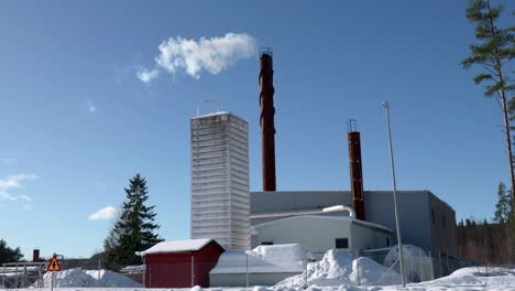 White-smoke-coming-out-of-a-chimney-on-district-heating-plant-on-a-cold-sunny-winter-day-in-Sweden