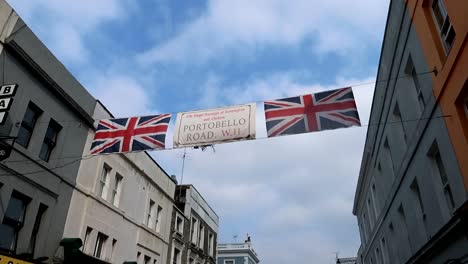 Statische-Ansicht-Der-Flaggen-Des-Vereinigten-Königreichs-In-Der-Portobello-Road,-Während-Wolken-Am-Himmel-Ziehen
