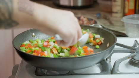 Frying-red-and-green-peppers-and-onions-in-a-Teflon-frying-pan-over-low-heat