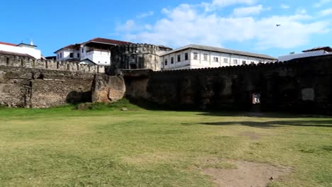 Local-stores-in-garden-of-old-Ngome-Kongwe-fortress-with-a-tourist-woman-appearing-walking